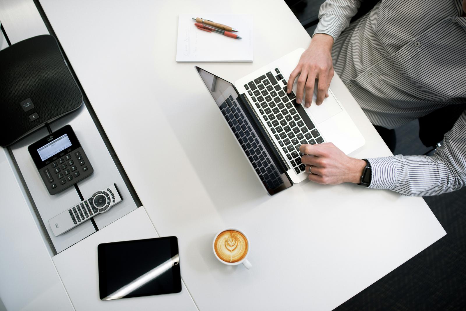 Office desk with an IP phone and laptop used for call campaigns