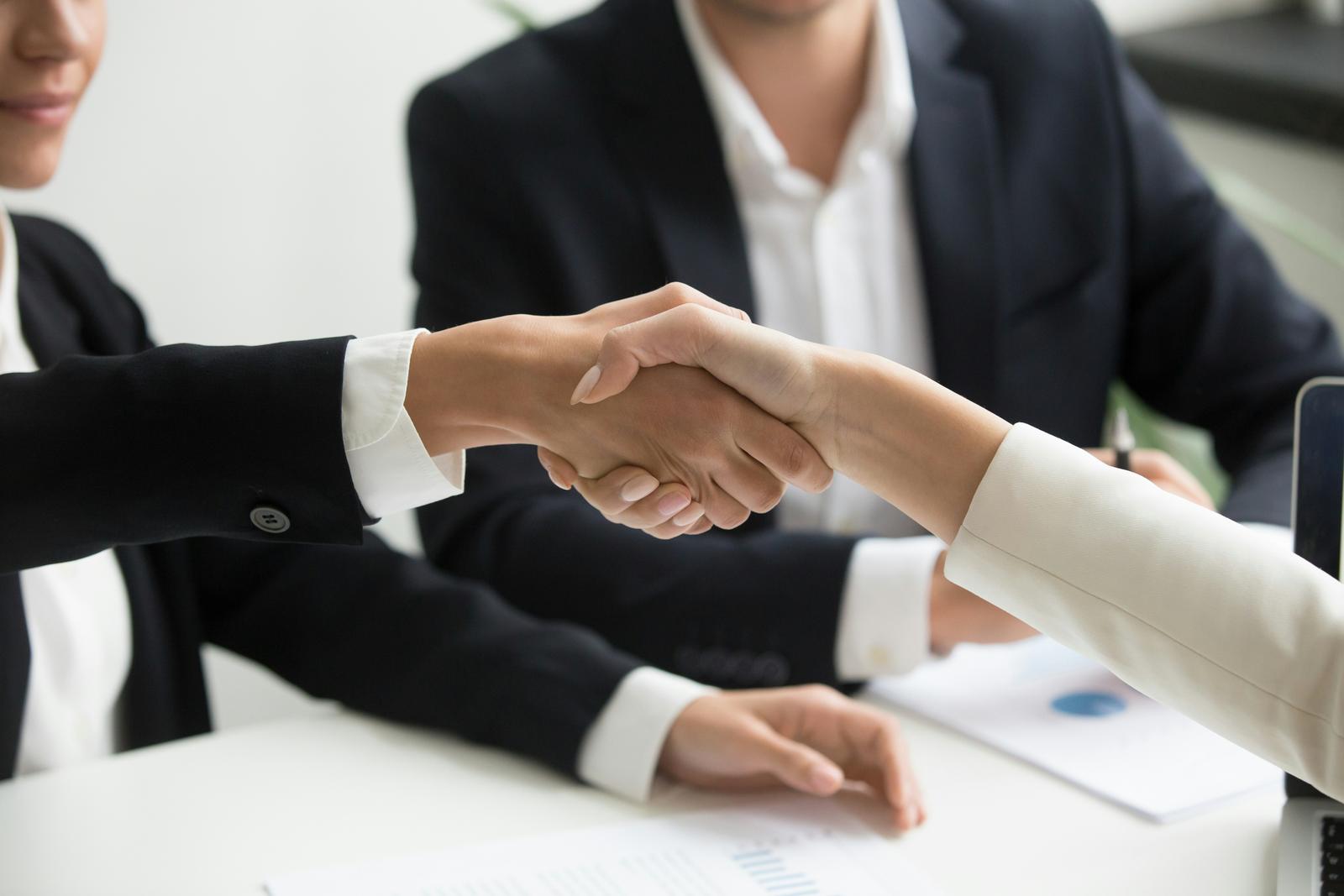 Two professionals shaking hands after exchanging contact details